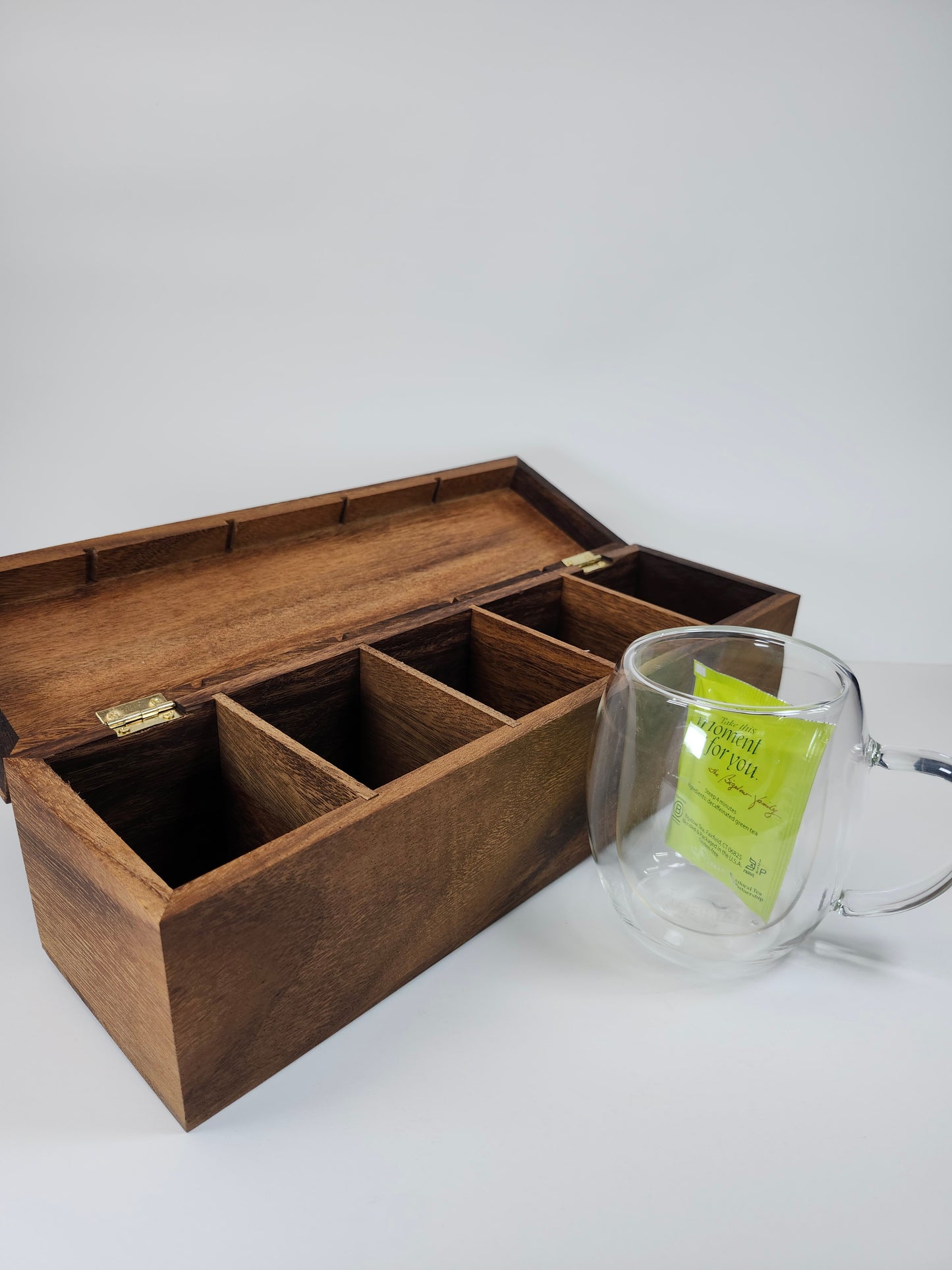 Interior view of a walnut tea box with multiple 2.5-inch wide by 3.25-inch deep compartments, holding various tea bags.