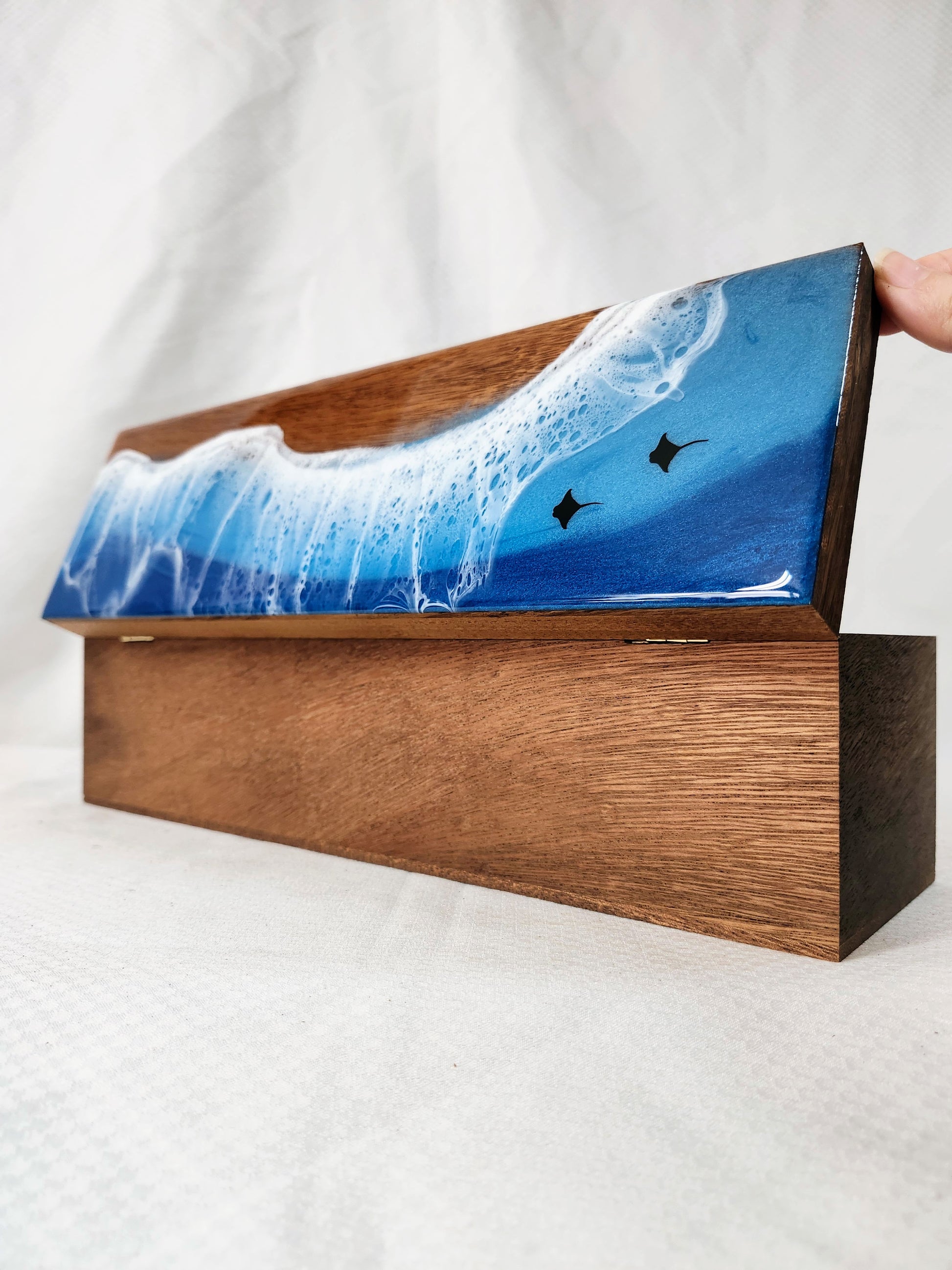 Wooden box with a blue wave design on a white background