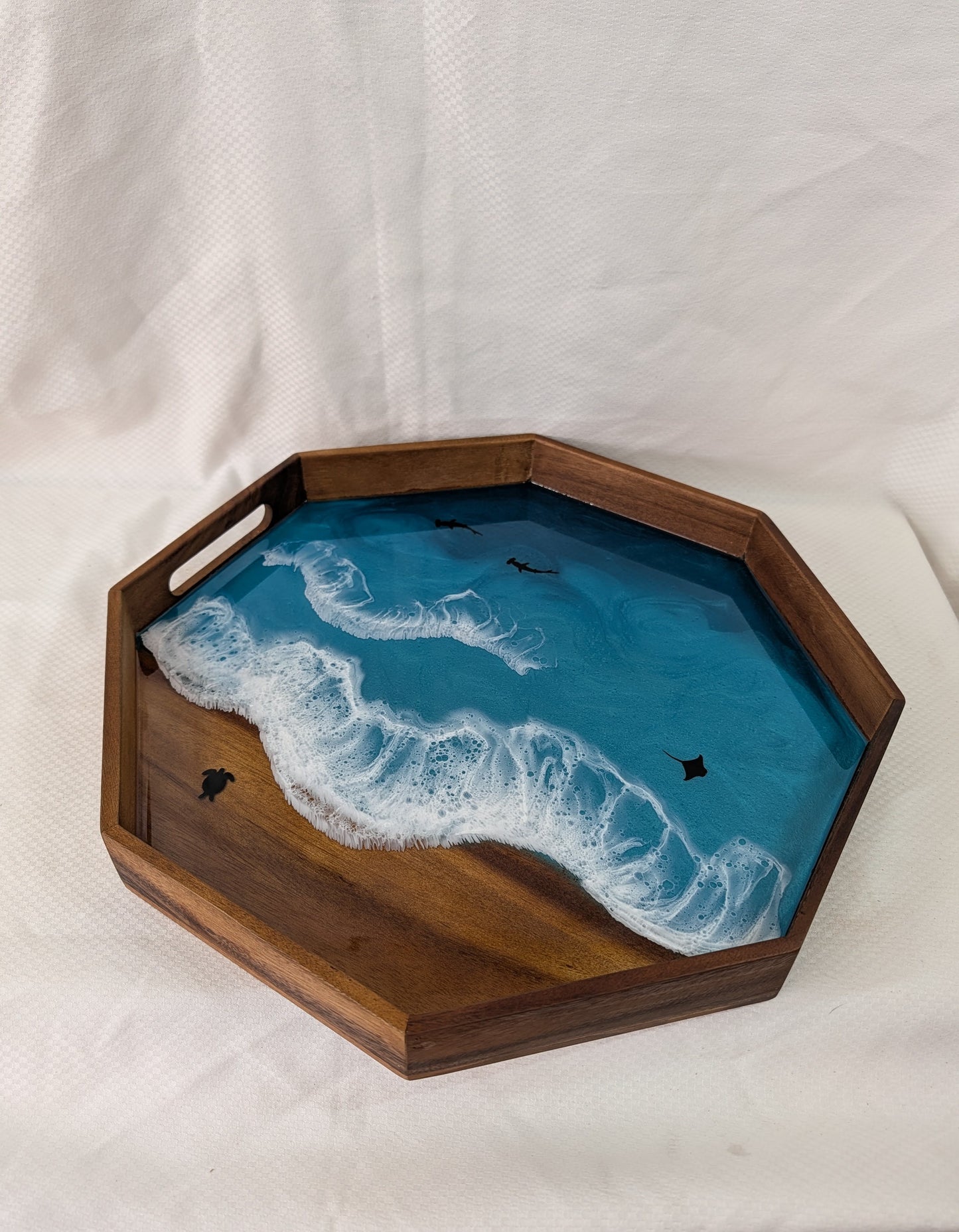 Wooden tray with a blue resin design resembling water and waves on a white background