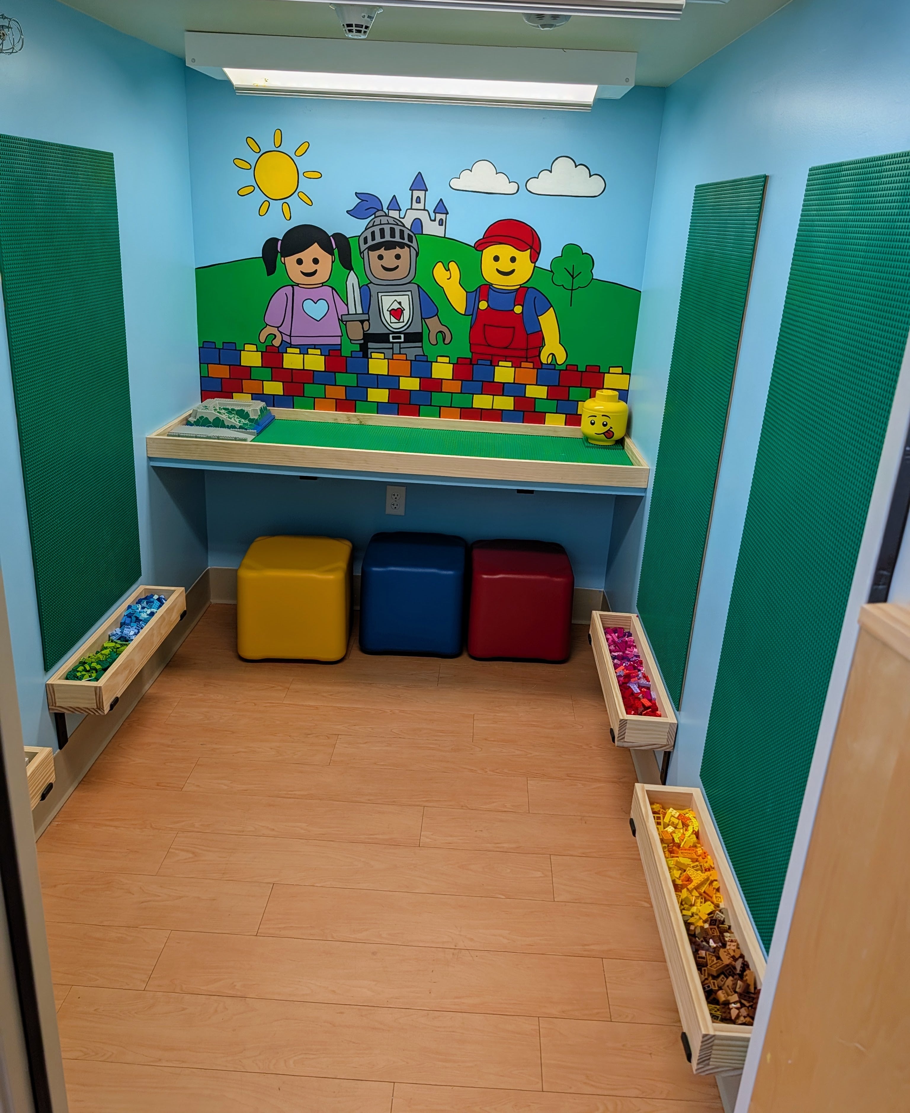 Children's playroom with colorful wall mural, toy storage, and wooden floor.